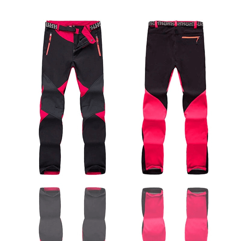 Sleek women's black and red softshell skiing pants with thermal fleece, ideal for outdoor trekking and available in vibrant colors.